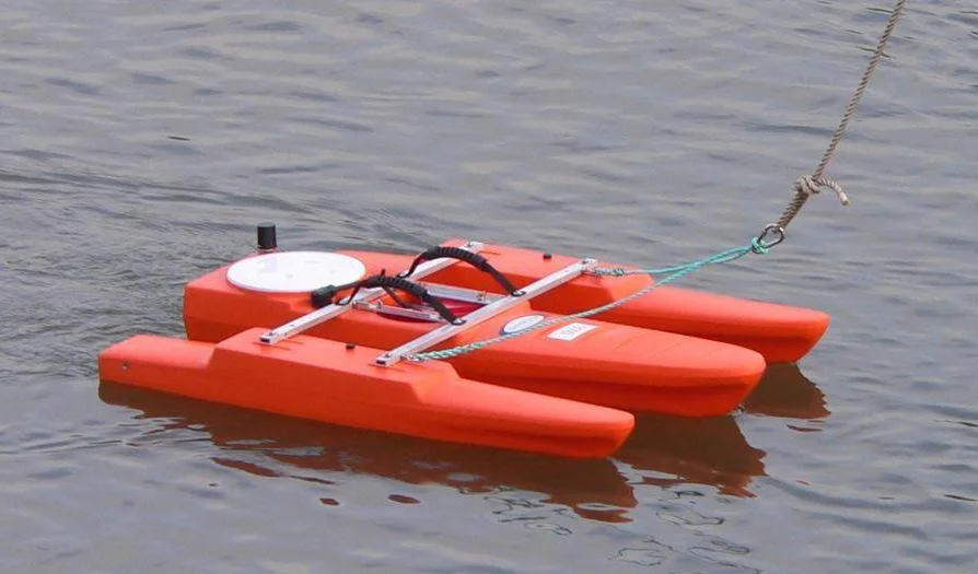 Orange tethered float carrying an ADCP, pulled across a river on a line
