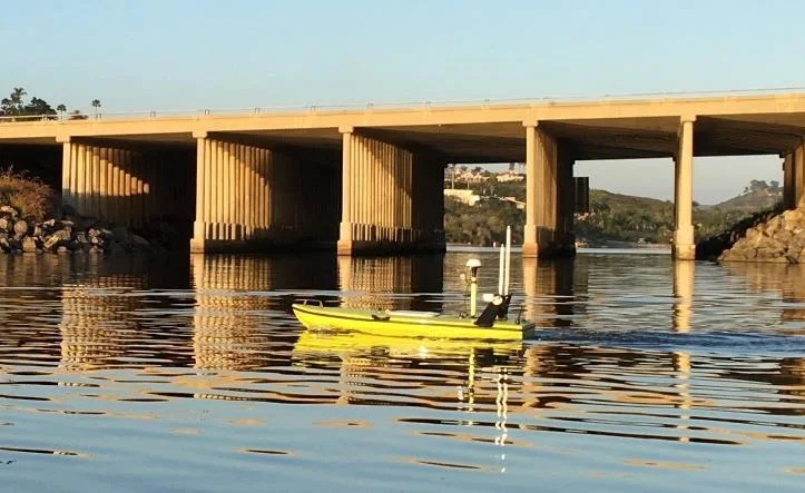 CEE-USV survey boat on the water near a bridge under autopilot control