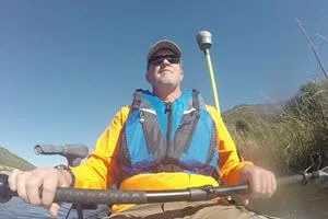 Surveyor in the kayak with the Trimble R10 GNSS antenna on a pole