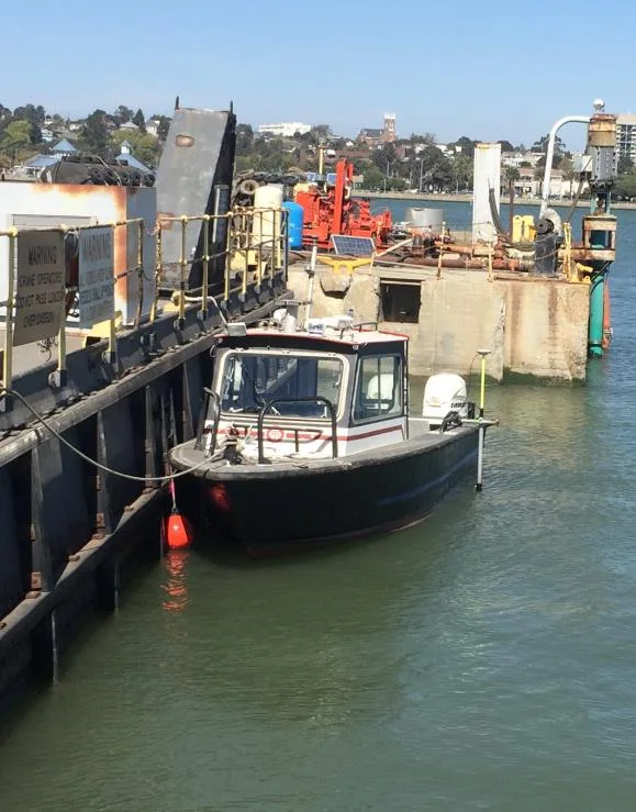 MIDD survey boat moored beside a dock on the water