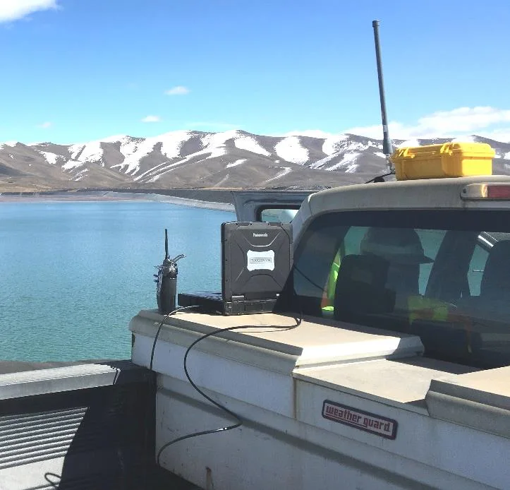 Rugged laptop and radio on a pickup tailgate, controlling the USV autopilot at the shore