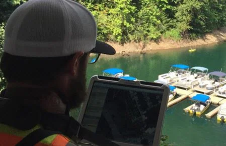 Operator watching the survey on a laptop above the marina
